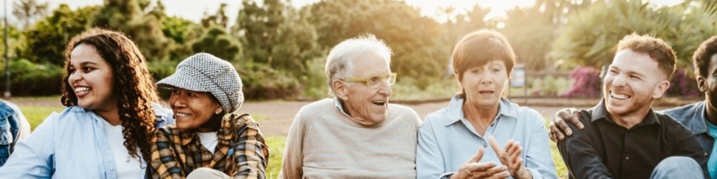 People sitting on a field smiling and chatting